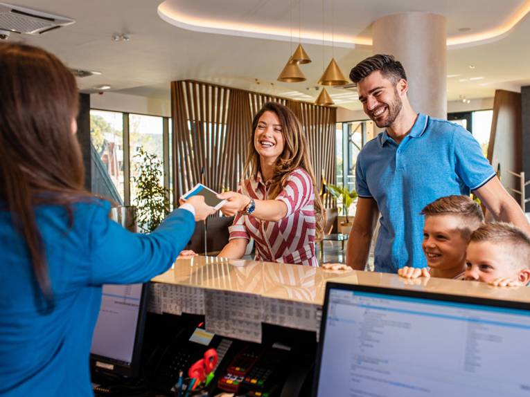 Familie beim Check-In im Hotel