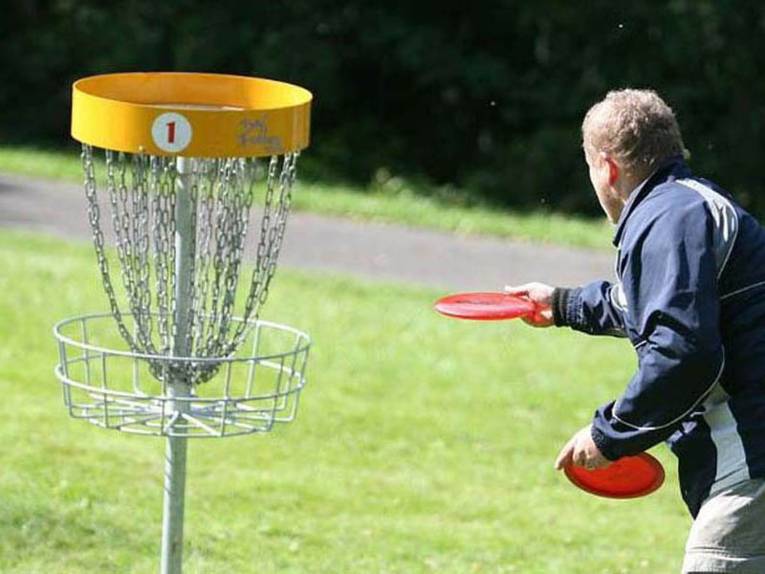 Ein Mann visiert einen Discgolf-Zielkorb an
